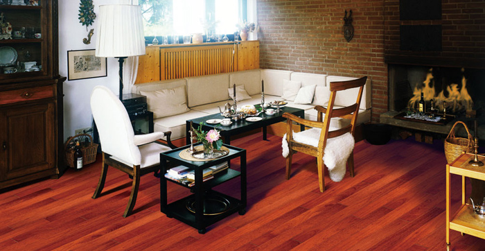 Hand-drawn ink illustration of a cozy living room with reddish wood flooring, a lit brick fireplace, and a white sectional sofa in a warm, inviting mood
